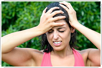 female athlete holding head in pain