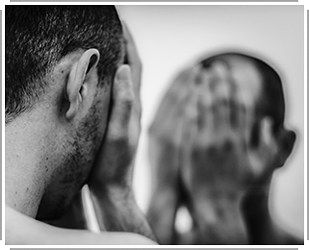 young man looking at self in mirror