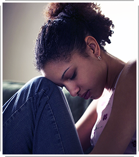 young woman sadly leaning head on knee