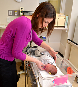 Woman performing ABR screening on baby