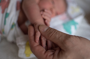 Adult holding baby's hand